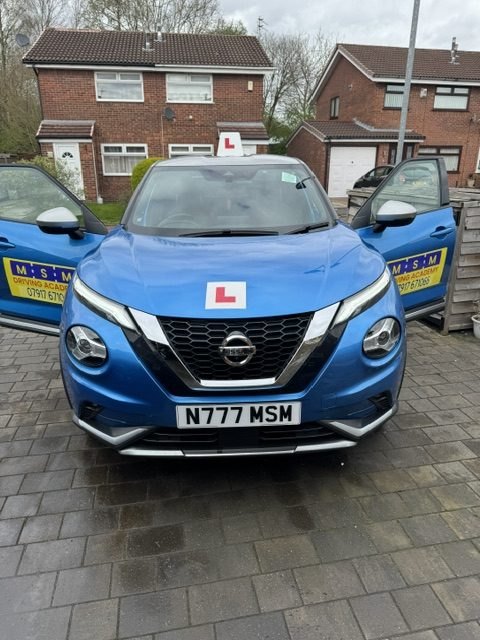 The blue Nissan Juke with its front doors open, ready for a lesson